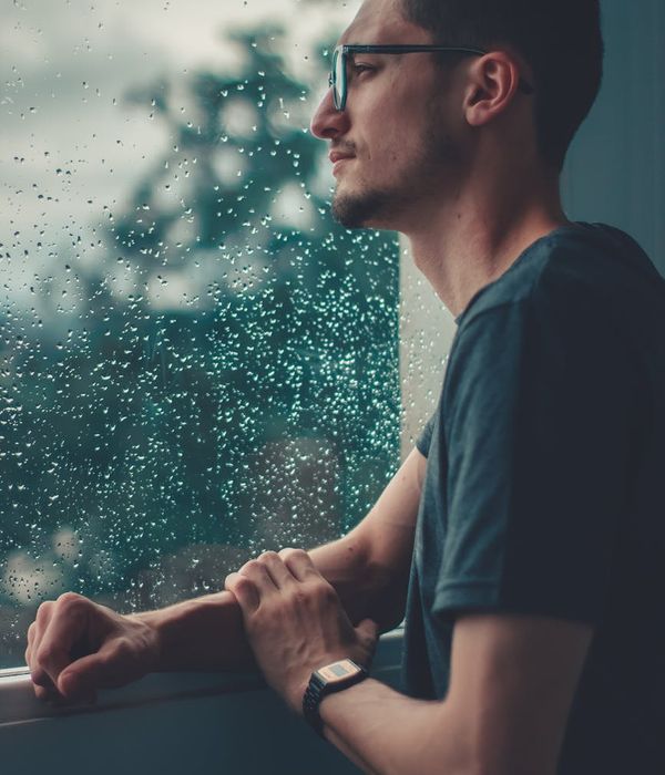 Man in a calm, focused state after a workout, looking out a window.
